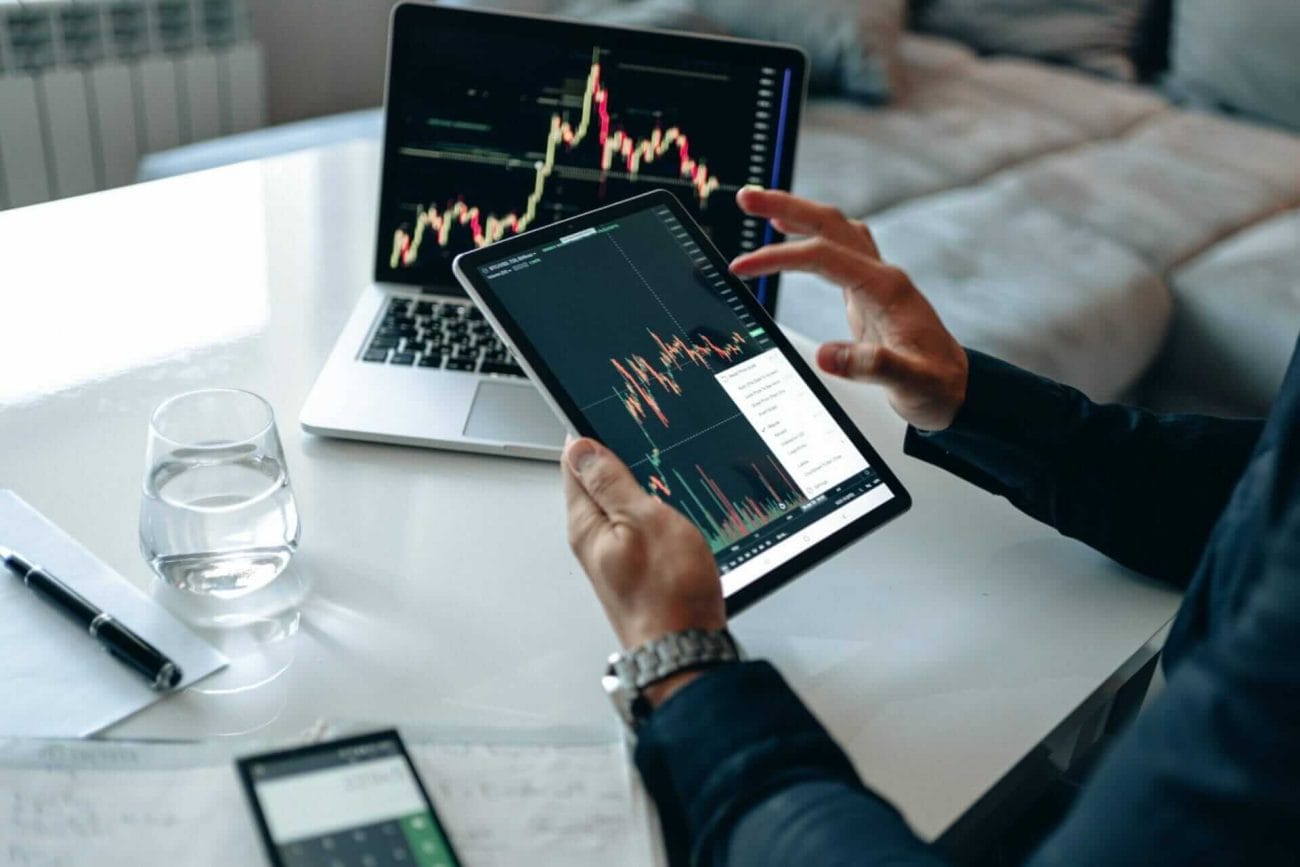 a man uses an app on a tablet to check the stock market