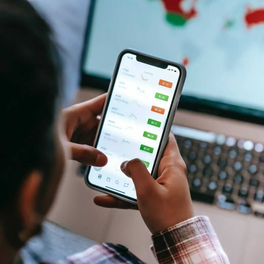 a man uses an app to trade on his mobile phone