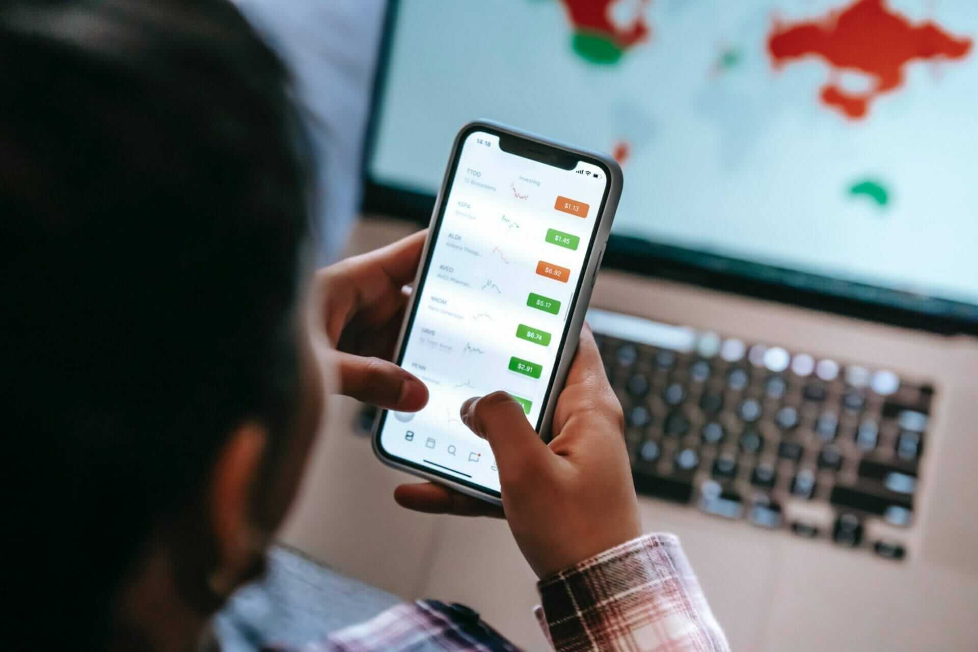 a man uses an app to trade on his mobile phone